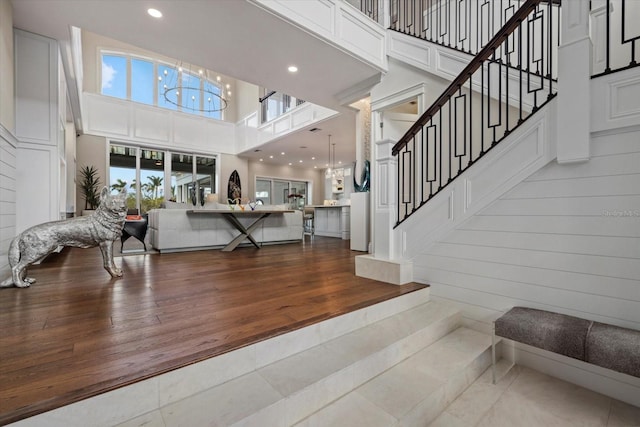 living room featuring a high ceiling, a notable chandelier, and wood-type flooring