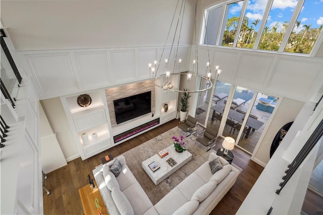 living room with dark hardwood / wood-style floors, an inviting chandelier, and a premium fireplace