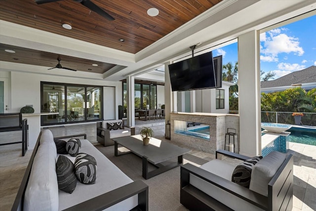 view of patio / terrace featuring outdoor lounge area, exterior bar, a fenced in pool, and ceiling fan