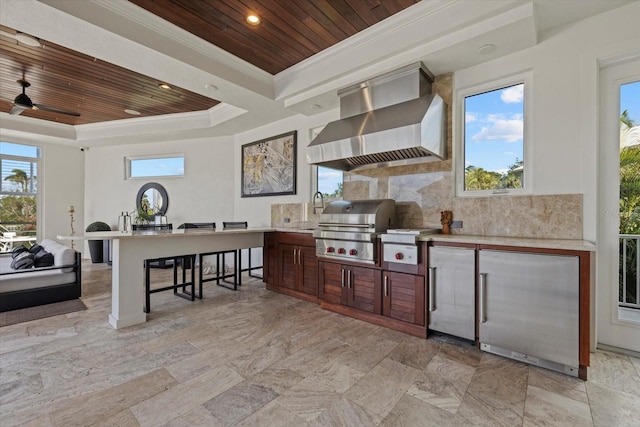 view of patio / terrace with ceiling fan, an outdoor kitchen, a wet bar, and a grill