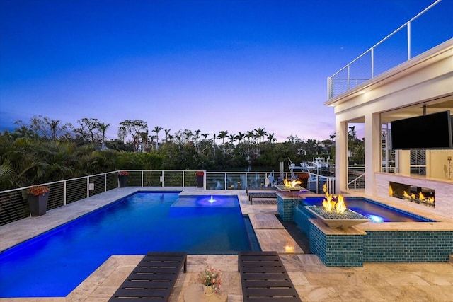 view of swimming pool featuring an in ground hot tub, a fire pit, and a patio area