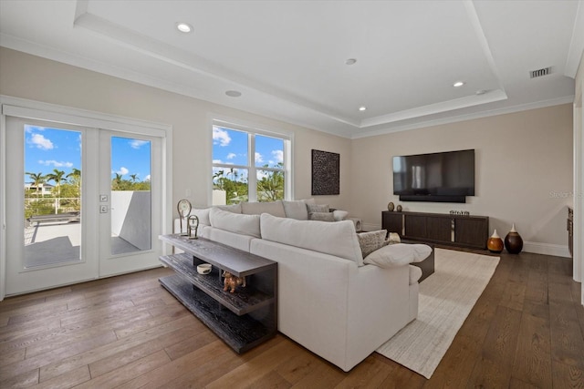 living room featuring a raised ceiling, hardwood / wood-style flooring, and french doors