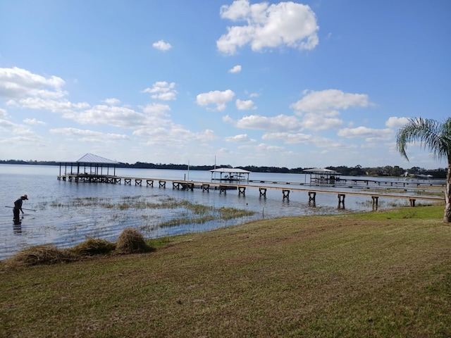 view of dock featuring a water view and a lawn