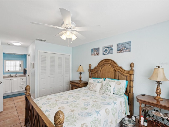 bedroom with light tile patterned floors, a closet, visible vents, ceiling fan, and a sink