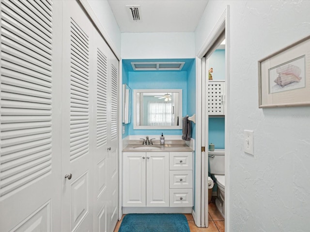 bathroom with vanity, toilet, and tile patterned flooring