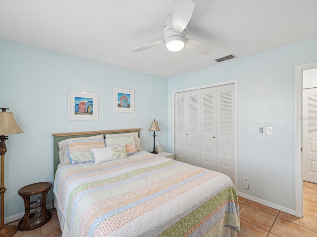 bedroom featuring a closet, visible vents, baseboards, and light tile patterned floors