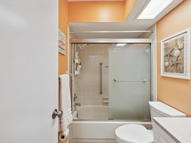 full bathroom featuring vanity, enclosed tub / shower combo, and toilet