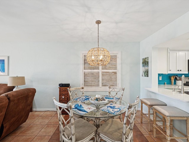 tiled dining area featuring sink and a chandelier