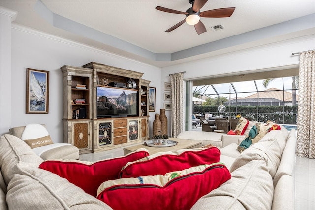 living room featuring ceiling fan and a raised ceiling