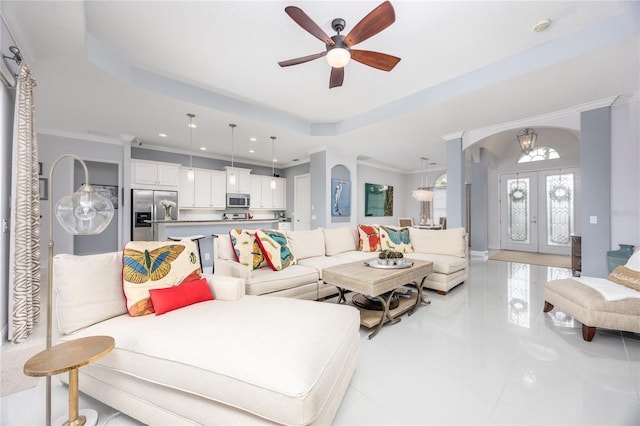 living room featuring french doors, crown molding, ceiling fan, and a tray ceiling