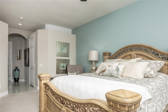 carpeted bedroom featuring ceiling fan and a textured ceiling