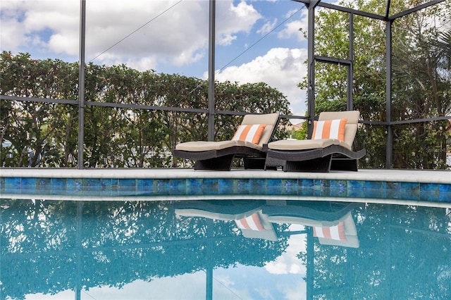 view of swimming pool featuring a lanai