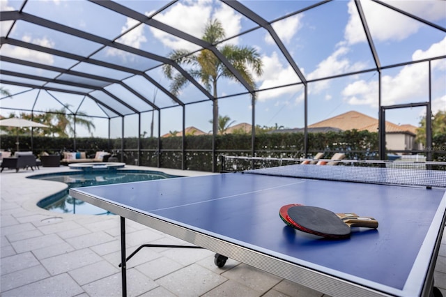 view of swimming pool featuring a patio and glass enclosure