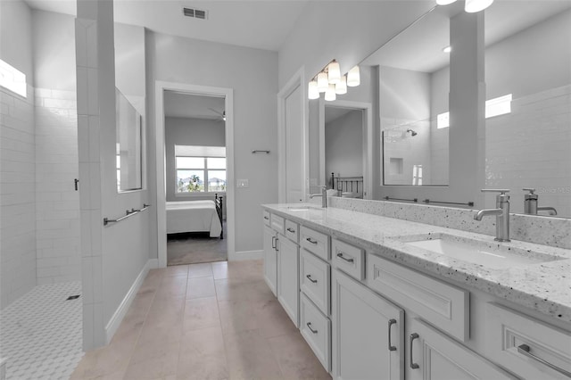 bathroom with ceiling fan, vanity, and a tile shower