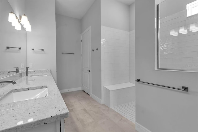 bathroom featuring tiled shower and vanity