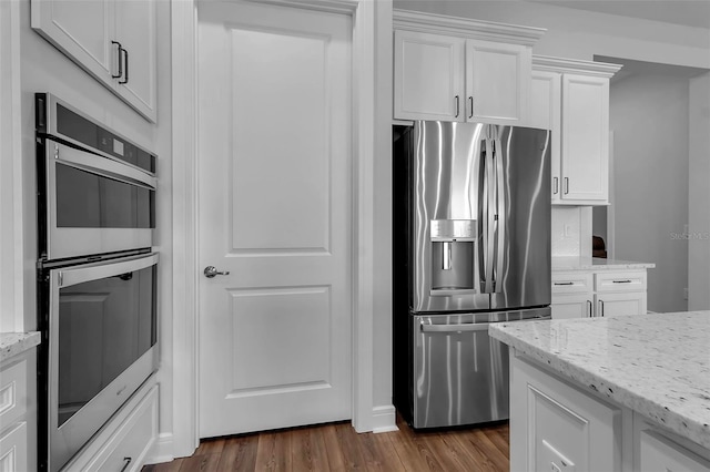 kitchen featuring light stone counters, stainless steel appliances, and white cabinets