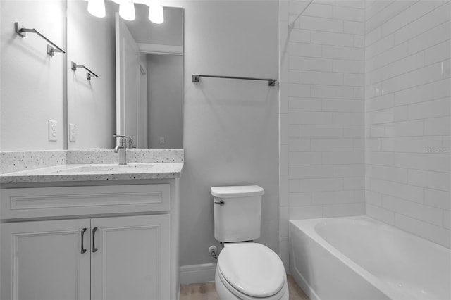 full bathroom featuring tiled shower / bath, vanity, and toilet