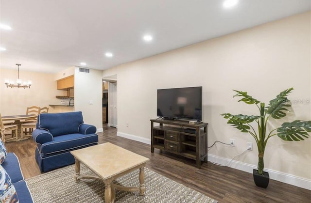 living room with an inviting chandelier and dark wood-type flooring