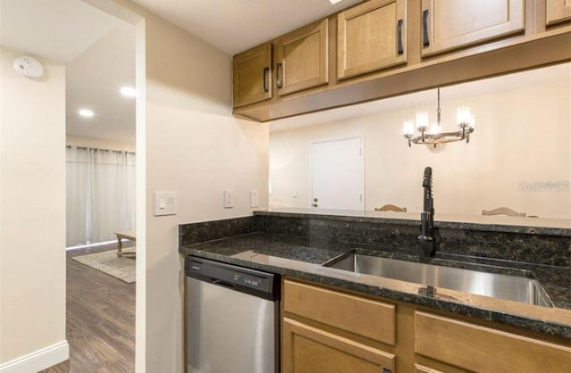 kitchen featuring dark hardwood / wood-style floors, sink, dark stone countertops, hanging light fixtures, and stainless steel dishwasher