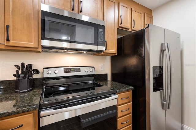 kitchen featuring dark stone countertops and appliances with stainless steel finishes