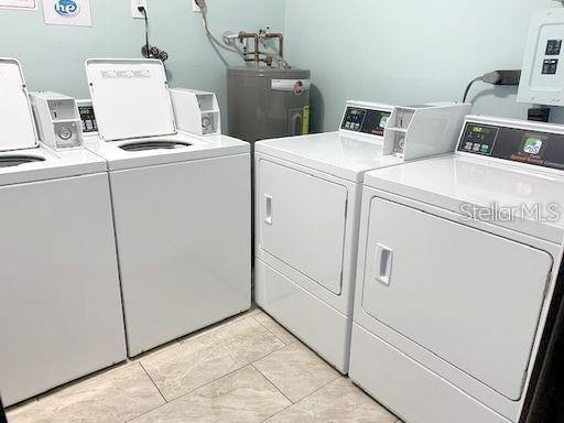 washroom with water heater, electric panel, and independent washer and dryer