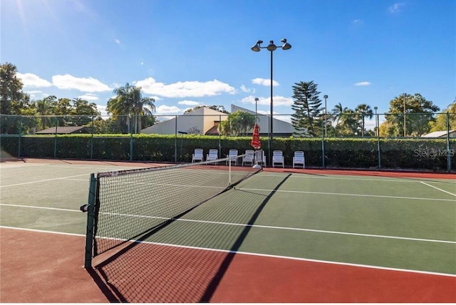 view of tennis court featuring basketball hoop