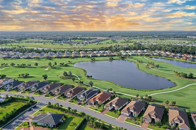 aerial view at dusk featuring a water view