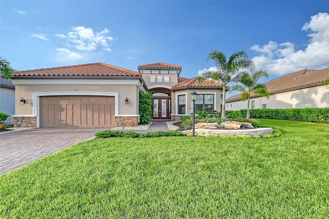 mediterranean / spanish home with french doors, a garage, and a front lawn