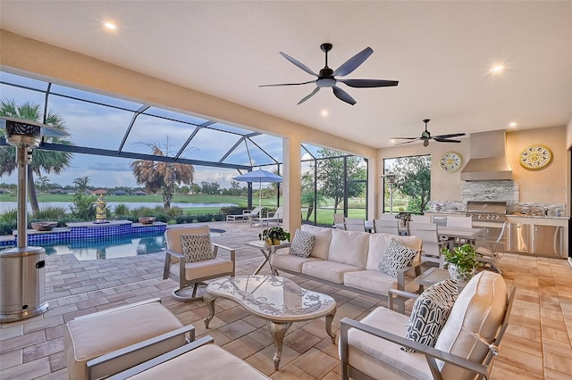 patio terrace at dusk with area for grilling, outdoor lounge area, glass enclosure, and a water view