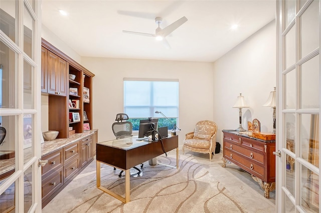 carpeted home office featuring french doors and ceiling fan