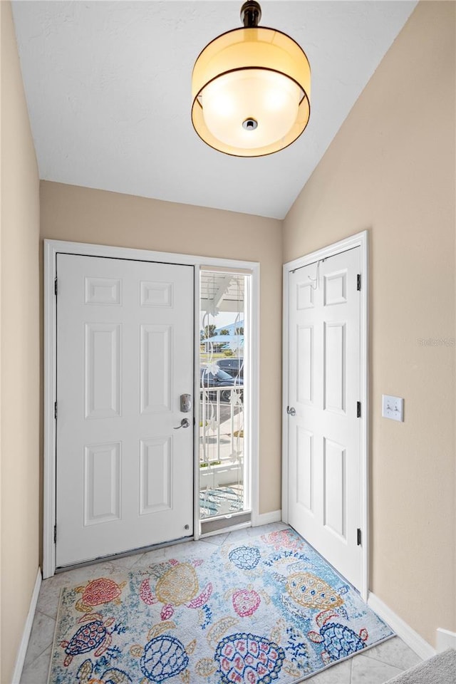 entrance foyer with lofted ceiling and light tile patterned floors