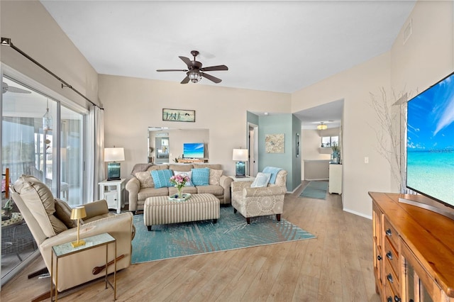 living room with ceiling fan and light hardwood / wood-style flooring