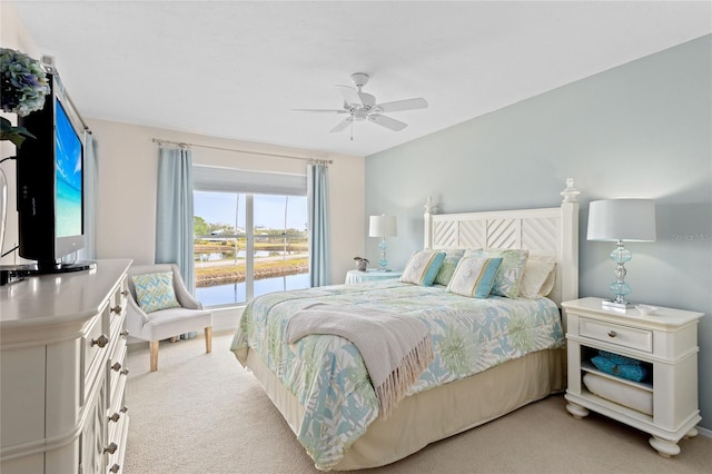 carpeted bedroom featuring a water view and ceiling fan