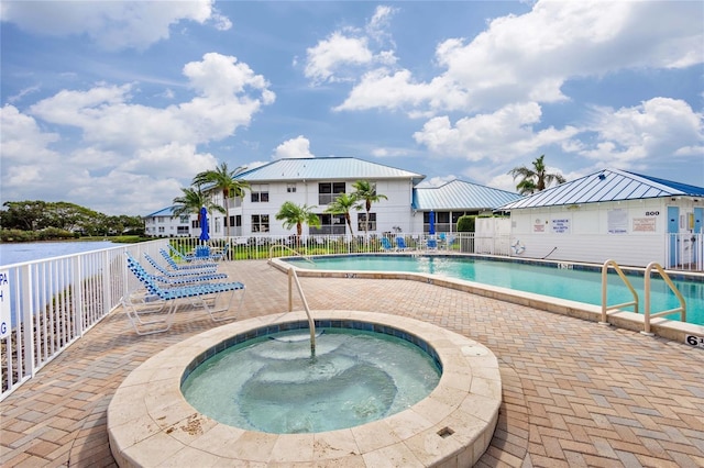 view of swimming pool with a hot tub