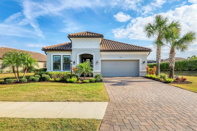 mediterranean / spanish house featuring a garage and a front yard