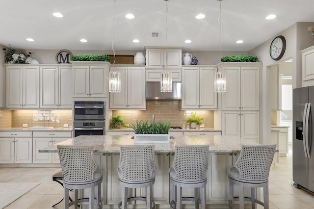 kitchen with pendant lighting, a kitchen island, white cabinets, and appliances with stainless steel finishes