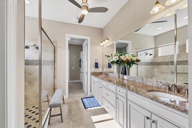 bathroom with tile patterned floors, a tile shower, vanity, and ceiling fan