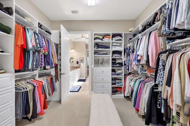 walk in closet featuring light colored carpet and ceiling fan