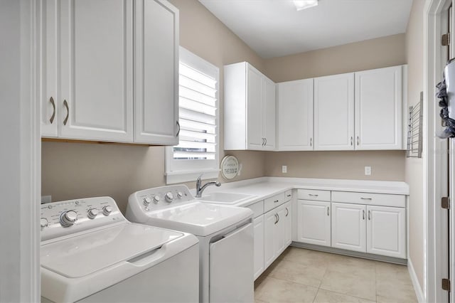 washroom featuring cabinets, light tile patterned floors, sink, and washing machine and clothes dryer