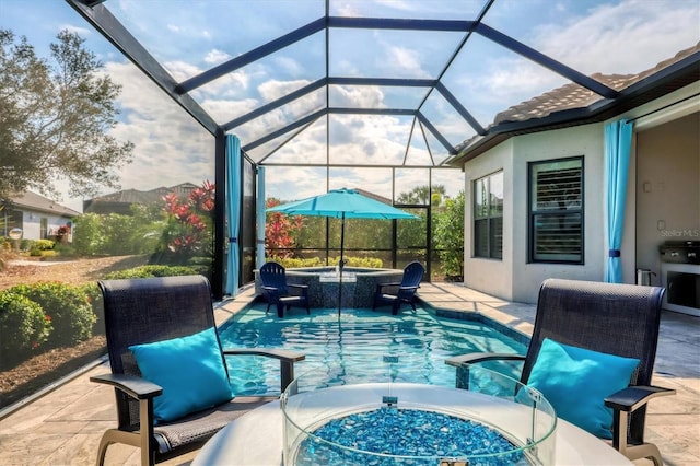 view of pool with a patio area, an in ground hot tub, and glass enclosure