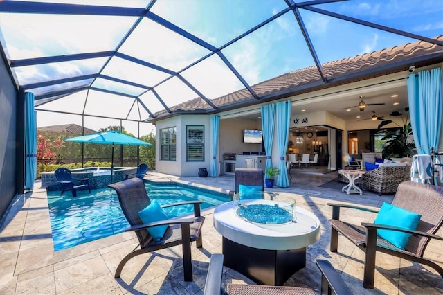 view of pool featuring a patio, glass enclosure, exterior kitchen, and an outdoor fire pit