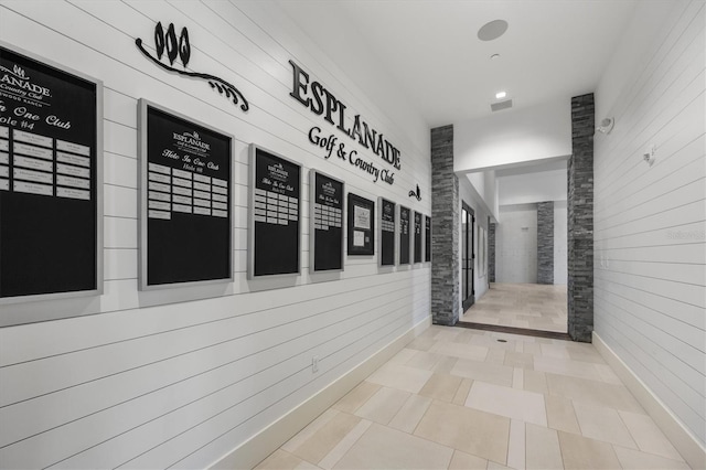 corridor featuring a mail area and wooden walls