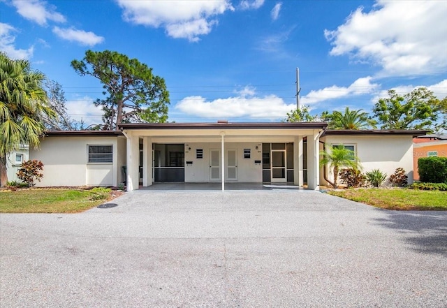 ranch-style home with driveway and stucco siding