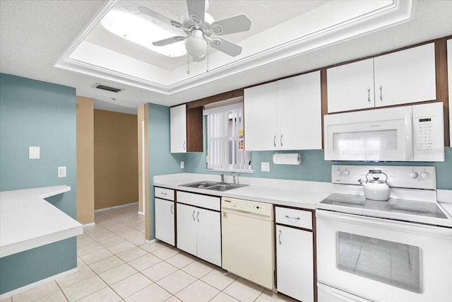 kitchen featuring white cabinets, white appliances, a tray ceiling, and light countertops