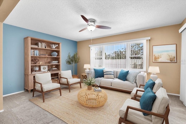 living area featuring ceiling fan, carpet floors, and baseboards