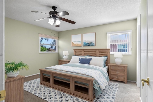 bedroom with a textured ceiling, baseboards, and light colored carpet