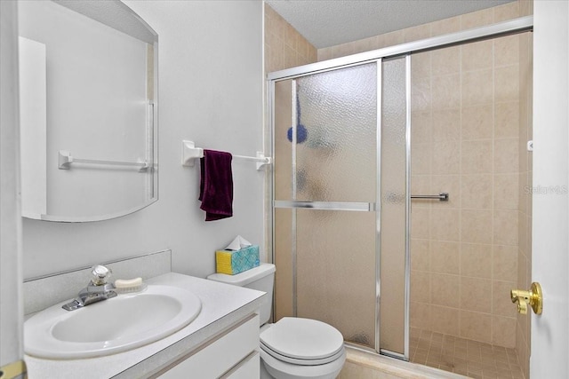 bathroom with a shower stall, toilet, and vanity