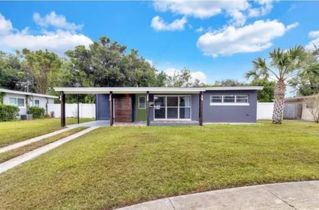 ranch-style home featuring a carport and a front lawn