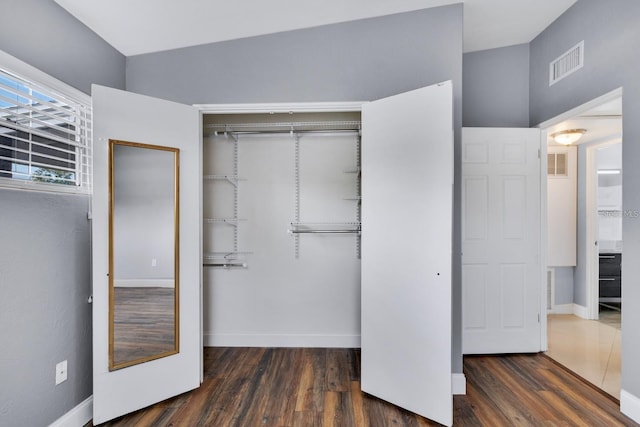 unfurnished bedroom featuring dark hardwood / wood-style flooring and a closet