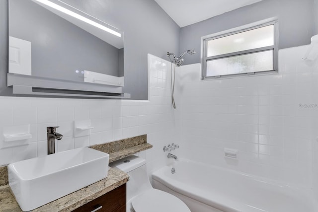 full bathroom with vanity, tiled shower / bath, tile walls, and toilet